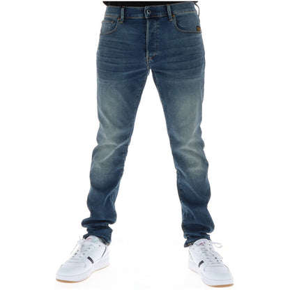 Image 1 : Jean slim G-Star homme en denim bleu effet usé porté avec des sneakers blanches Lacoste, vue frontale — Delvale